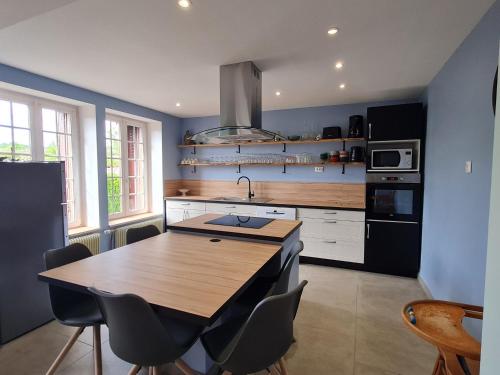 Il comprend une cuisine avec une table et des chaises en bois. dans l'établissement Charme et authenticité : Gîte 6 pers, rénové, jardin, proche commerces et randonnées - FR-1-585-86, à Mauvages