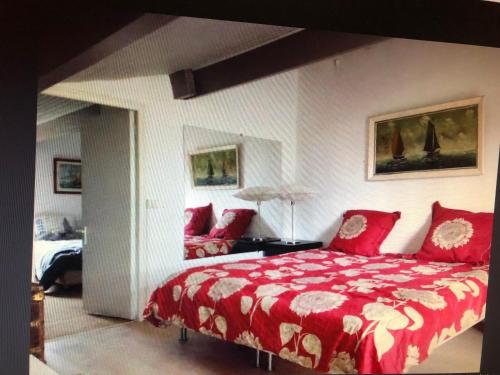- une chambre avec un grand lit rouge et un canapé dans l'établissement Petite maison de charme avec piscine et pins centenaires, à Nîmes
