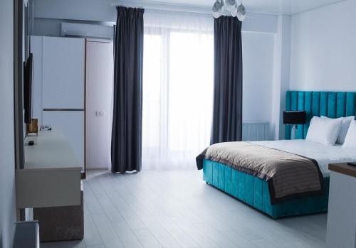 a bedroom with a bed and a large window at Hotel Building Stefan Resort I in Mamaia Nord