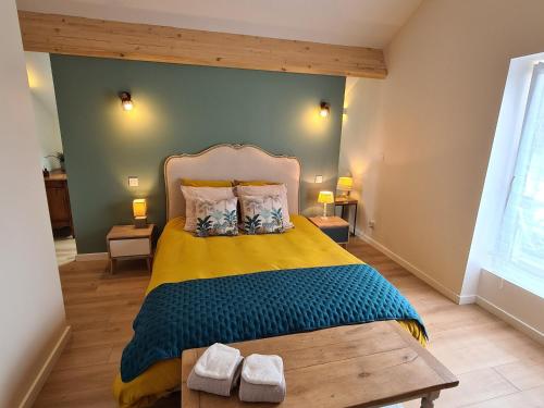 Schlafzimmer mit einem Bett mit gelber und blauer Decke in der Unterkunft Gîte Artenay, 5 pièces, 10 personnes - FR-1-590-255 in Artenay
