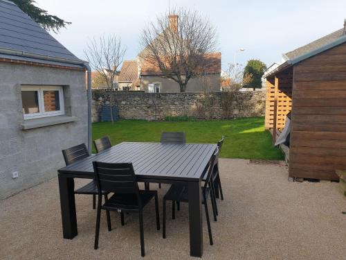 a black table and chairs in a backyard at Charmant gîte au cœur du Val de Loire, proche châteaux, Orléans, avec jardin et équipements complets - FR-1-590-258 in Sigloy