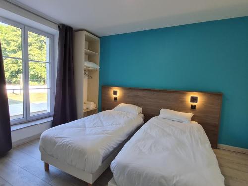 two beds in a room with a blue wall at Appartement Lacroix-sur-Meuse, 2 pièces, 2 personnes - FR-1-585-91 in Lacroix-sur-Meuse