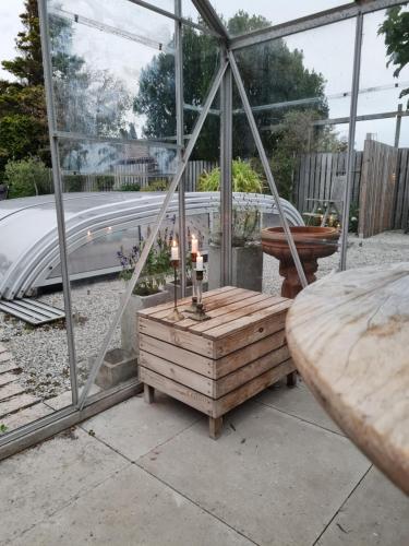 a greenhouse with a table and candles in it at 47 By the sea in Höganäs