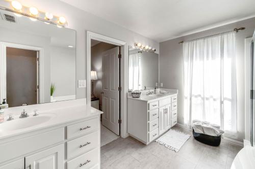 un bagno bianco con due lavandini e un grande specchio di about 3 Mi to Dtwn Aubrey Vacation Rental with Patio! a Aubrey