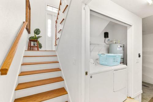 a white staircase in a home with white walls and wooden floors at 4BR house, 2 blocks from the beach in Saint Augustine