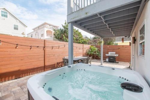 a hot tub on a patio with a wooden fence at 4BR house, 2 blocks from the beach in St. Augustine
