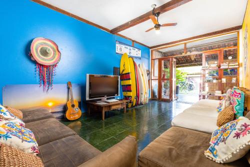 Drifter Hostel في بارا دو ساهي: غرفة معيشة مع أريكة وتلفزيون وألواح ركوب الأمواج
