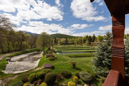 a view of a park with benches and a river at Complex Pastravaria Albota in Arpaşu de Sus