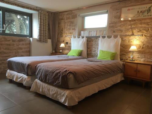 - une chambre avec 2 lits et des oreillers verts dans l'établissement Écogîte avec Terrasse et Jardin Privatif pour Familles - FR-1-584-187, à Havange
