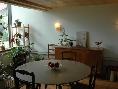 - une table et des chaises avec un bol de fruits dans l'établissement Écogîte avec Terrasse et Jardin Privatif pour Familles - FR-1-584-187, à Havange