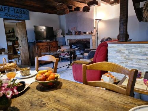 un salon avec une table avec un bol de fruits dessus dans l'établissement Suite Familiale Privatisée avec Petit Déjeuner, Salon et Chambres au 1er Étage - FR-1-591-396, à Châteauroux