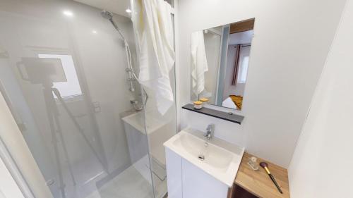 a white bathroom with a shower and a sink at Camping SIBLU - La réserve in Gastes