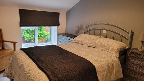 a bedroom with a bed and a window at Coatham Cottage in Barton