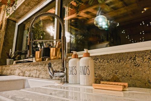 - deux bouteilles assises sur un lavabo dans la salle de bains dans l'établissement FHandCO, Loft and Music Studio, à Damas-aux-Bois