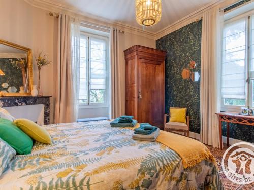 a bedroom with a large bed and windows at Maison de maître avec piscine et jardin - cœur des Coteaux du Layon, proche Angers et Saumur - FR-1-622-55 in Faye-dʼAnjou