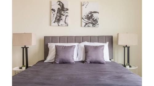 a bedroom with a large bed with two lamps at Stunning Nulu 1BR CozySuites 01 in Louisville
