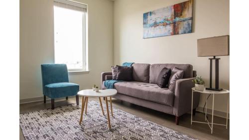 a living room with a couch and a chair at Stunning Nulu 1BR CozySuites 03 in Louisville
