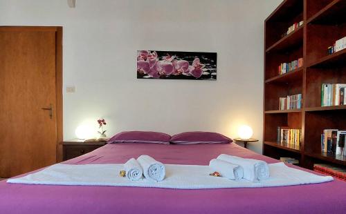 1 Schlafzimmer mit einem lila Bett und 2 Handtüchern in der Unterkunft Da Fabio e Francesca - Holiday Apartment in Verona