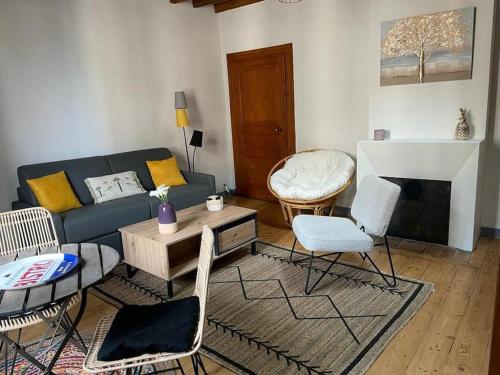 un salon avec un canapé, une table et des chaises dans l'établissement Le Duplex de la Reine - T3 Cosy au cœur de Chambéry, à Chambéry