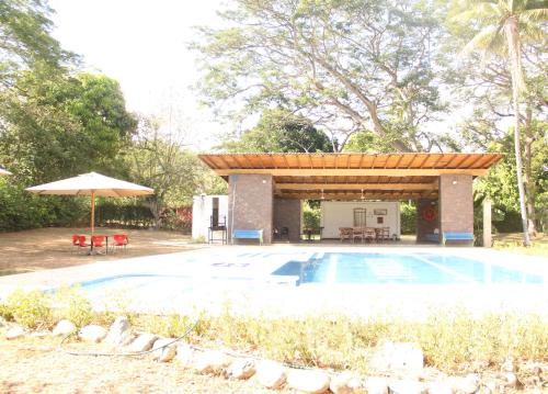 a swimming pool with a pavilion next to a pool at Hermosa Finca La Rochela, Santa fe de Antioquia in Santa Fe de Antioquia