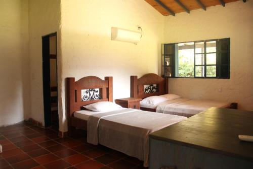 a bedroom with two beds and a window at Hermosa Finca La Rochela, Santa fe de Antioquia in Santa Fe de Antioquia