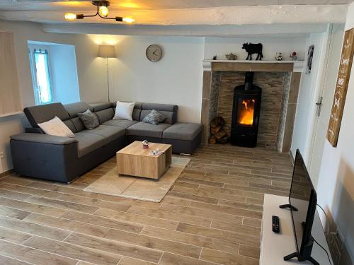 a living room with a couch and a fireplace at Maison de vacances rénovée à la ferme, terrasse, proche du Parc Ardes, Puy de Dôme et Brioude - FR-1-582-375 in Autrac
