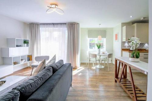 a living room with a couch and a table at Exquisite Apartment with Balcony, Free Parking, Fast WiFi, and Smart TV by Yoko Property in Milton Keynes