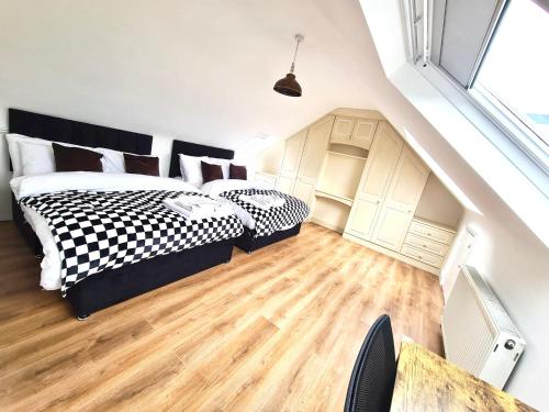 um quarto com 2 camas com lençóis brancos e pretos em Beautiful quiet Victorian Bungalow heart of London em Londres