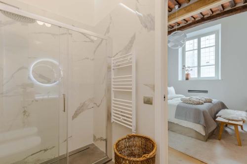 a bathroom with a shower and a bed in a room at Casa Lazzaro Contemporary Ground Floor Apartment in Lucca