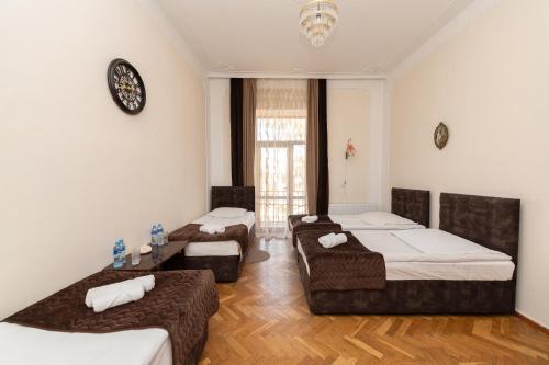 een kamer met drie bedden en een tafel erin bij Anna's Guest House in Gori