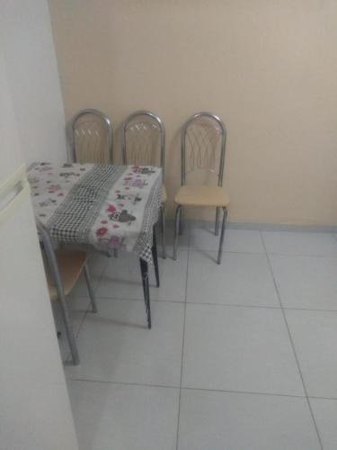 uma sala de jantar com uma mesa e quatro cadeiras em UINQUEND em São Vicente