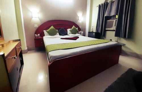 a bedroom with a large bed with a red headboard at Hotel swapanlok, Couple Friendly Hotel in Muzaffarpur