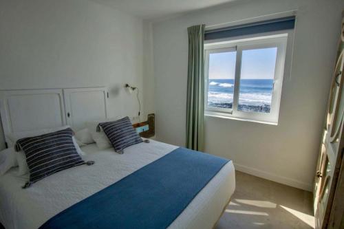 um quarto com uma cama e uma grande janela em Apartamento Valeron em El Golfo