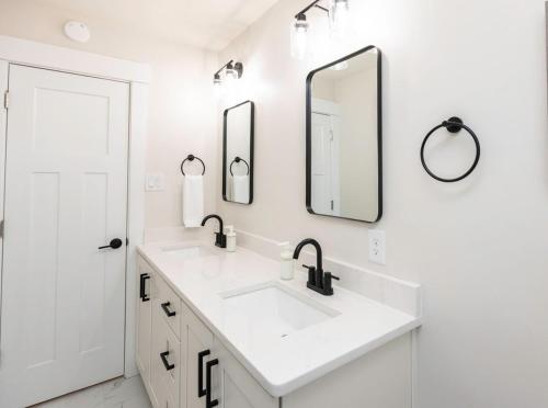 a white bathroom with two sinks and two mirrors at The Beach Vibe with Hot tub 8 min to the Beach in Virginia Beach