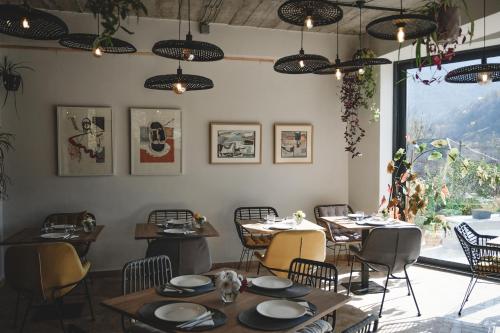 Un comedor con mesas y sillas y una ventana. en Debed Life CoLiving and Retreat, en Debed