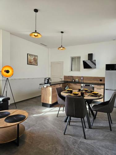 une pièce avec une table et des chaises et une cuisine dans l'établissement Métamorphose Champenoise, à Épernay