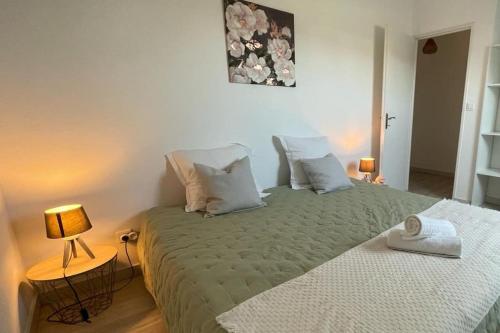 een slaapkamer met een bed met een groen dekbed bij Maison des Bruyères in Bracieux