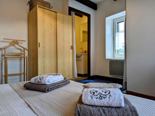 a bedroom with a bed with towels on it at Évasion au cœur de Polignac : Charme et confort à deux pas du Puy-en-Velay - FR-1-582-382 in Polignac