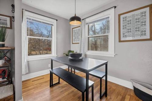 a dining room with a table and two windows at Casa Mosaic Executive Rental 3bedroom Smart TV in Colorado Springs