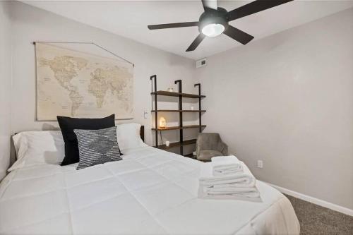 a bedroom with a white bed with a ceiling fan at Casa Mosaic Executive Rental 3bedroom Smart TV in Colorado Springs
