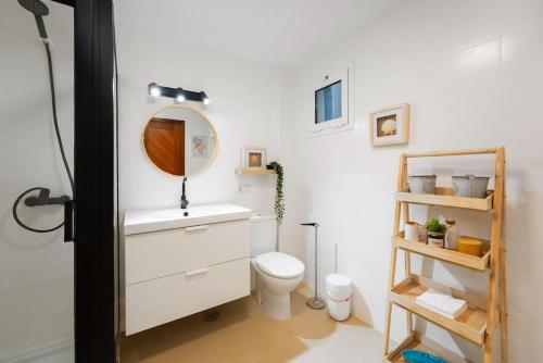 ein Badezimmer mit einem WC, einem Waschbecken und einem Spiegel in der Unterkunft Casa Any Lanzarote in Playa Honda