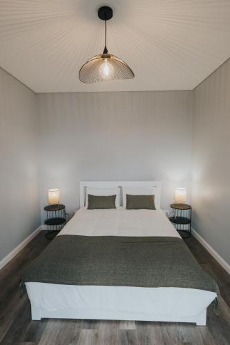 a bedroom with a white bed and two lamps at Pico Apartment's in Câmara de Lobos
