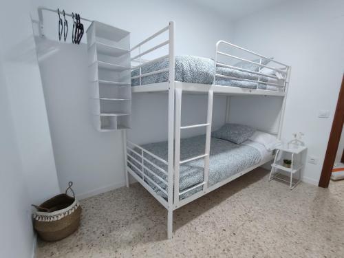 卡馬斯的住宿－Precioso apartamento en Sevilla.，白色客房内的白色双层床