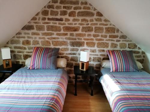 Niort-la-Fontaine的住宿－Guestroom Lassay-les-Châteaux, 1 pièce, 2 personnes - FR-1-600-231，石墙客房的两张床