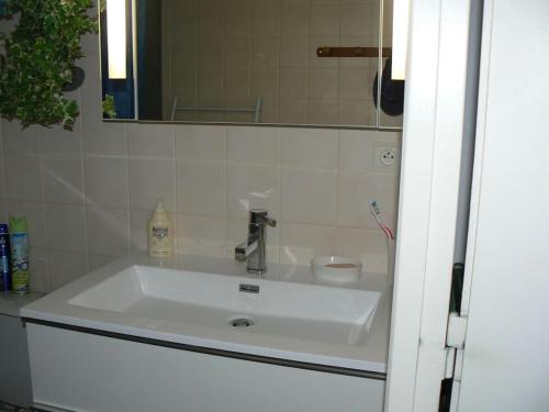 um lavatório branco na casa de banho com um espelho em FACE MER PORNICHET BAIE DE LA BAULE GRAND STUDIO em Pornichet