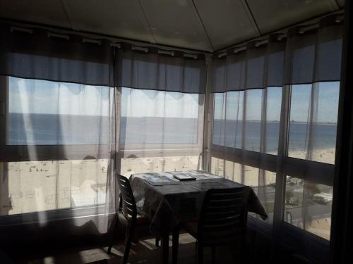 - une table dans une chambre avec vue sur l'océan dans l'établissement FACE MER PORNICHET BAIE DE LA BAULE GRAND STUDIO, à Pornichet