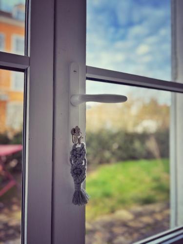 une poignée de porte sur une fenêtre donnant sur une cour dans l'établissement Le jardin de l'arbre sec + parking, proche château., à Fontainebleau