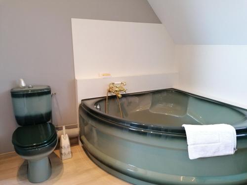 baño con bañera verde y aseo en Guestroom Renazé, 1 pièce, 2 personnes - FR-1-600-229, en Congrier