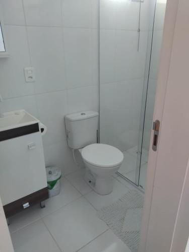 a white bathroom with a toilet and a shower at APARTAMENTO INTEIRO BELA ARTE COSTA E SILVA, 2 QUARTOS in Joinville