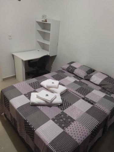 a bedroom with a bed with a table and a desk at APARTAMENTO INTEIRO BELA ARTE COSTA E SILVA, 2 QUARTOS in Joinville